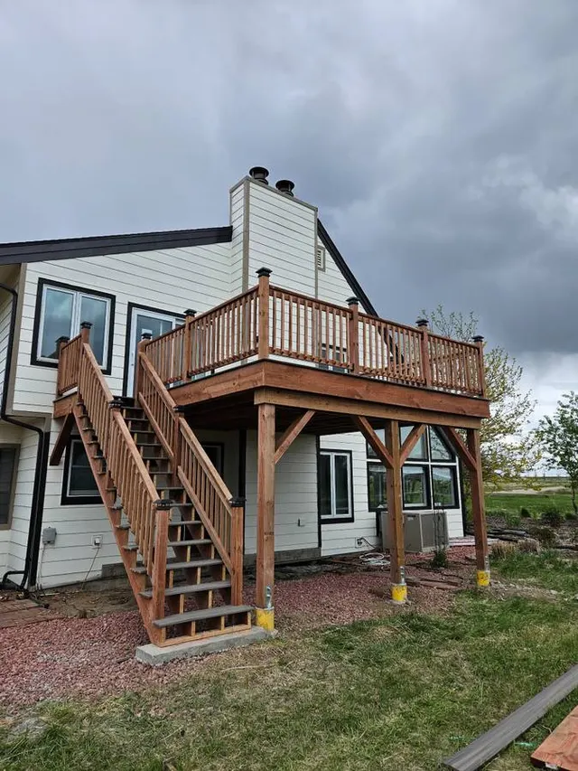 Elevated wood deck with stairs and railing on a Colorado home